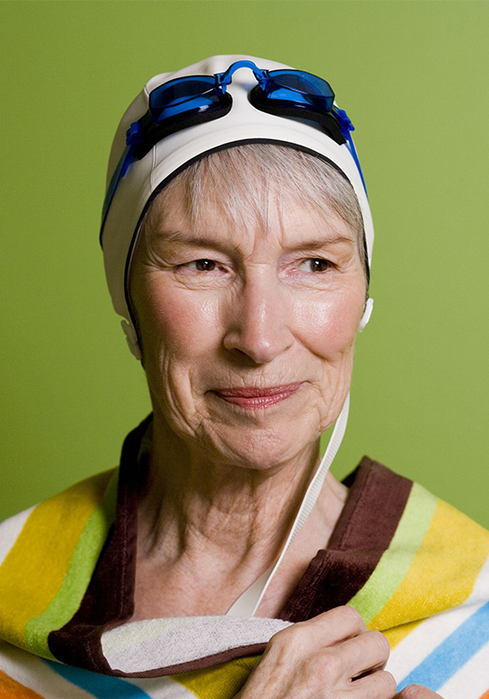 woman in swimming cap and goggles with towel wrapped around her