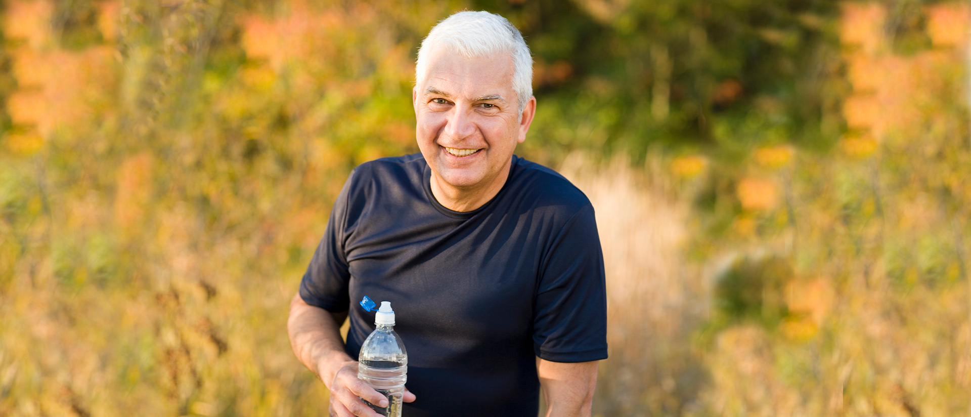 man smiling with water bottle 
